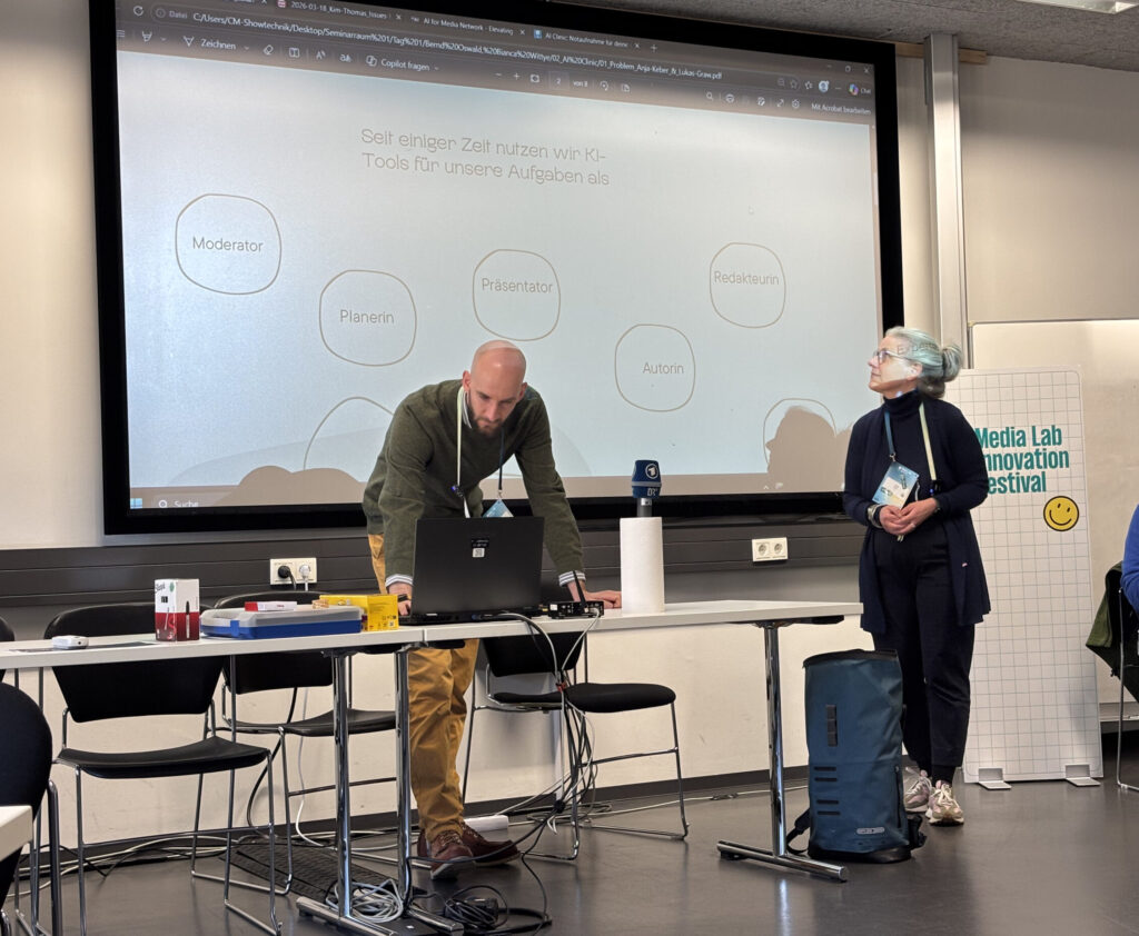 Ein Mann und eine Frau vor einem Monitor